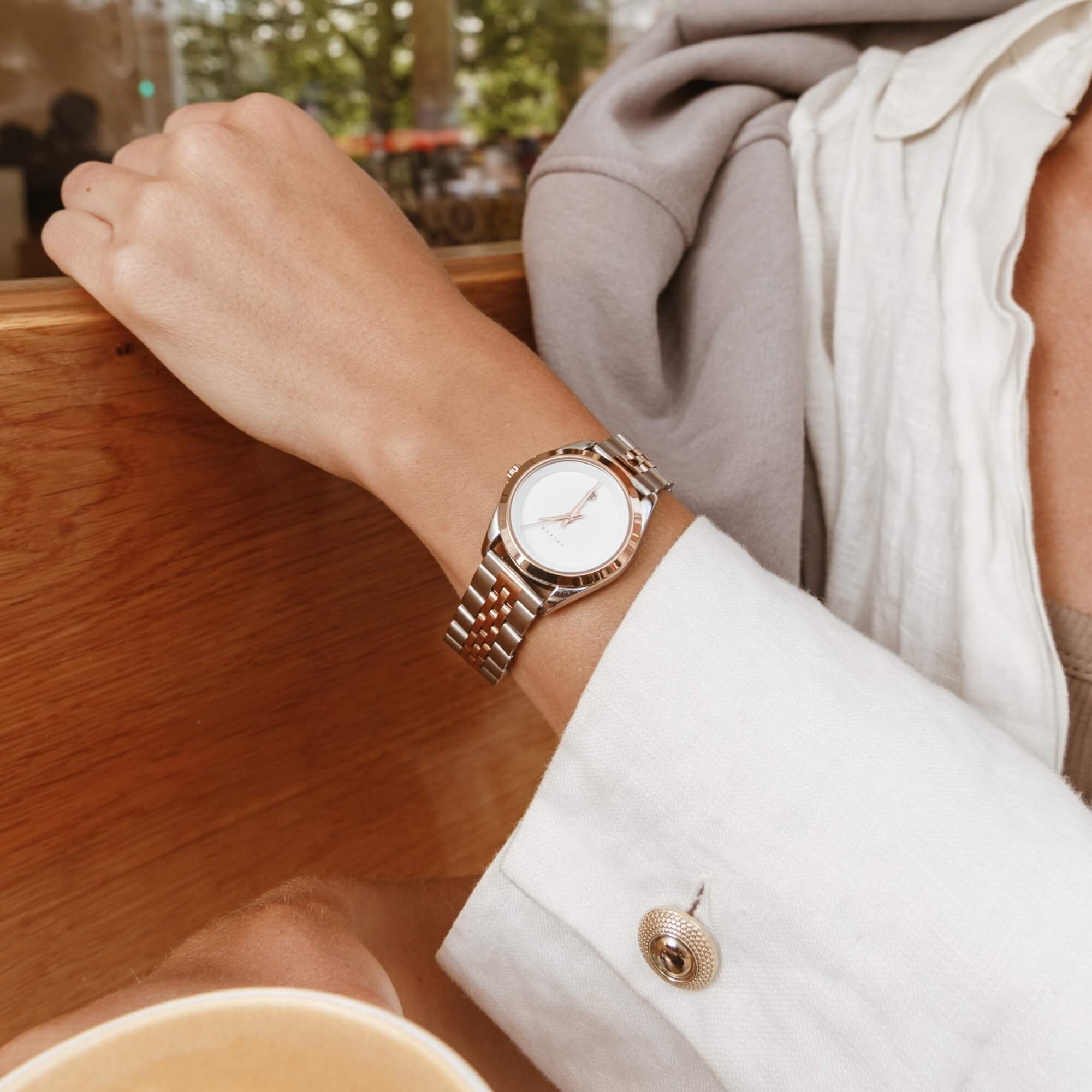 Reloj Valkur para mujeres modelo Agda de acero plateado con bisel dorado y fondo blanco
