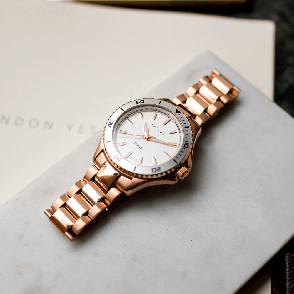 Reloj Valkur modelo Horus acero dorado con bisel plateado y fondo blanco
